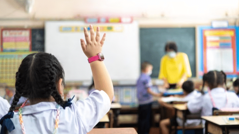 elementory children raising hand in classroom